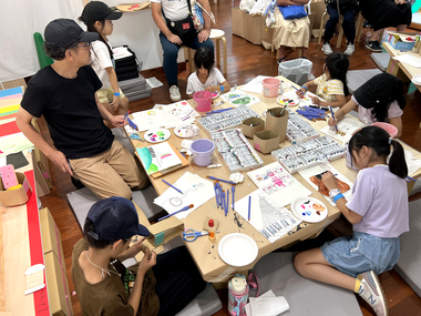 小池アミイゴのだれでも絵が描けるワークショップ・1歩目「シブヤ街歩きスケッチ」（2025年9月28日実施）で交流スペースで色塗りをする様子