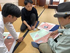 実際に光島氏が触り、その様子を芝野氏と今村氏が見ている。