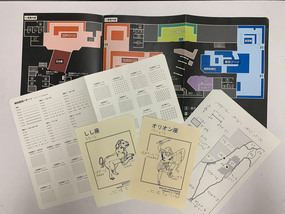 触図、触察用パンフレットが並べられている様子。「しし座」「オリオン座」と書かれた星座の触図冊子や、点字一覧表などが配置されている。